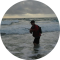 a person standing on a beach and icon